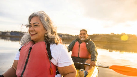 Older couple enjoying canoeing together on a lake at sunset